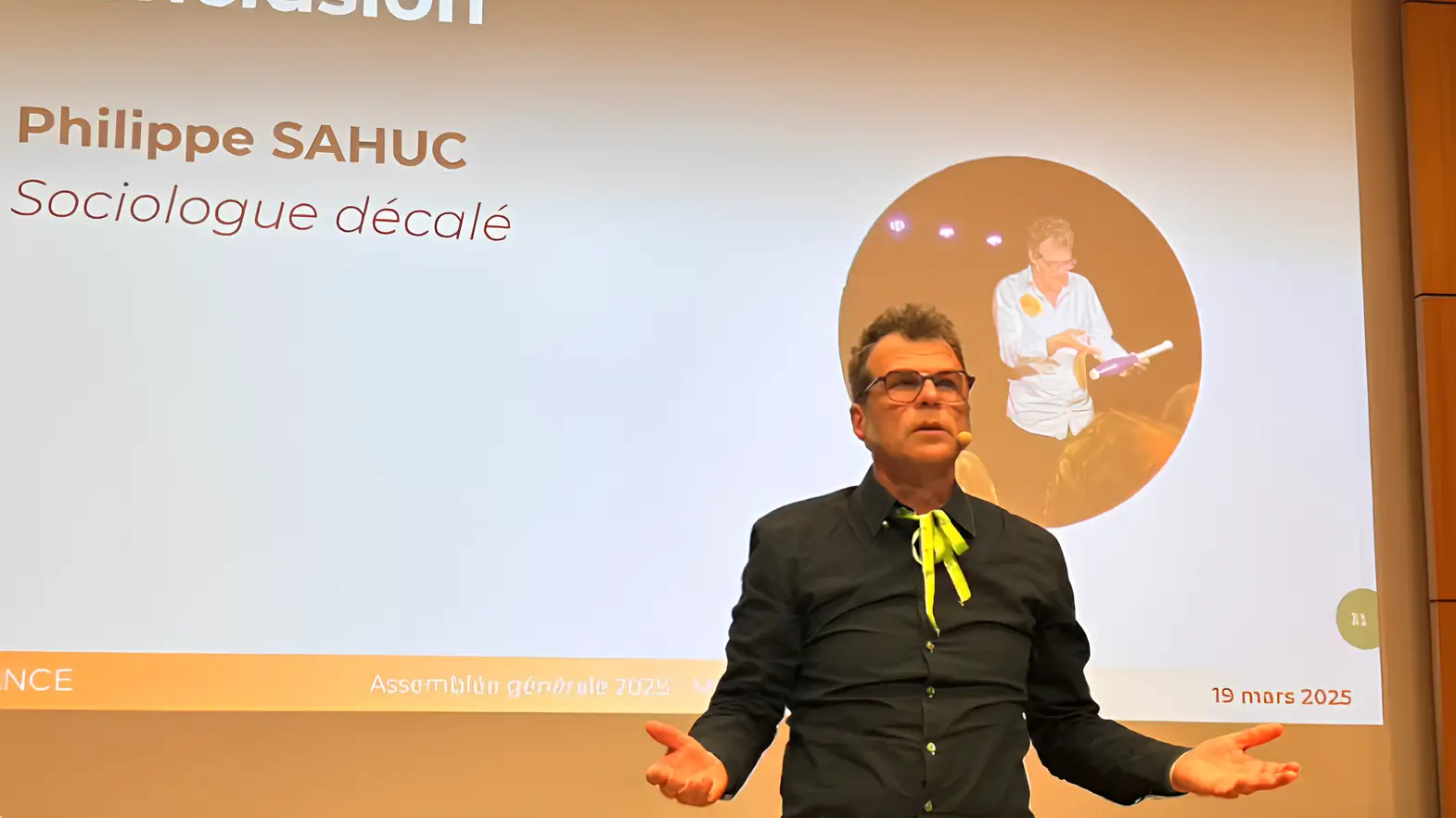 Philippe Sahuc, sociologue décalé, anime une conférence en France avec cravate jaune fluo